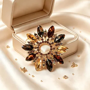 Gros plan d'une élégante broche fleur en cristal rétro avec des pierres ambrées, détail.