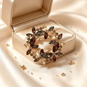 Gros plan d'une broche fleurie en cristal vintage, strass scintillants aux tons ambrés chauds.