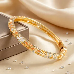 Vue détaillée d'un bracelet jonc fleur en émail doré vintage avec de charmants strass.