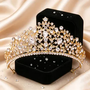 Close-up detail of luxury gold bridal tiara with sparkling rhinestones on black velvet box.