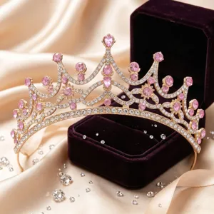 Close-up detail of a stunning gold tiara crown adorned with sparkling pink rhinestones.