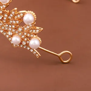 Detalle de tiara de novia dorada con pedrería brillante y perlas elegantes para boda.
