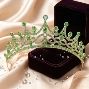 Exquisite green rhinestone bridal crown tiara close-up shot with velvet box and satin background.
