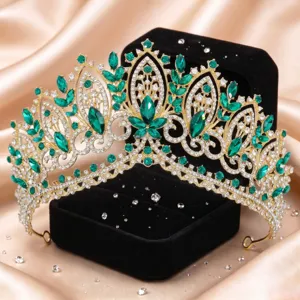 Nahaufnahme einer luxuriösen goldenen Barock-Tiara mit funkelnden grünen und klaren Strasssteinen.