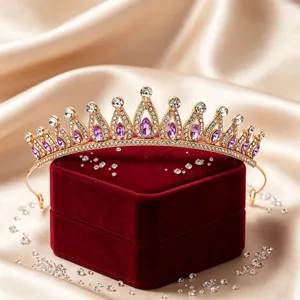 Exquisite gold bridal tiara with purple rhinestones on a red velvet box, detailed view.