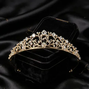 Gold crystal tiara crown detailed close-up, luxury sparkling party princess hair accessory.