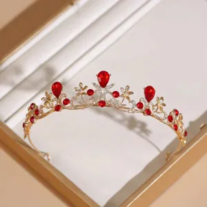 Elegante gouden bruidstiara met rode strass-stenen en bloemen voor huwelijksfeest.