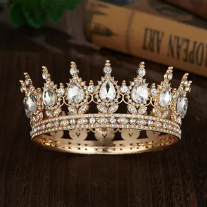 Detailed close-up of a vintage Baroque gold crown with sparkling rhinestones and teardrop stones.