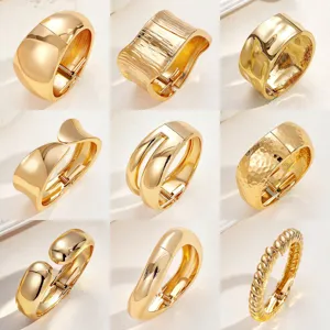 Klobige goldfarbene Legierungs-Armreifen mit unregelmäßigen Wellen und glatten Oberflächen.