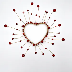 Close-up detail of the heart-shaped red bead wire decoration, showing fine craftsmanship.