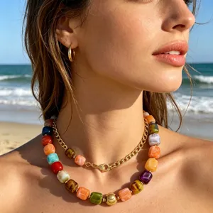 Nahaufnahme der farbenfrohen Harzperlenkette mit goldener Kette im Freien am Strand.