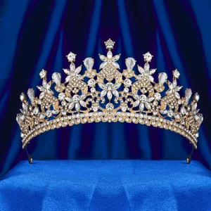 Primo piano dettagliato di una lussuosa tiara da sposa in strass dorati su sfondo blu.