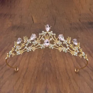 Close-up detail of a gorgeous gold princess crown tiara featuring sparkling pink crystals and rhinestones.