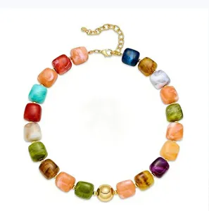 Bunte Harzperlen Halskette Detail, geometrisches Design mit goldener Kette und Zentralperle.