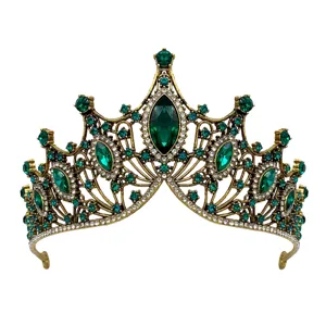 Detailed view of luxury baroque bridal tiara, antique gold alloy crown with green rhinestones.