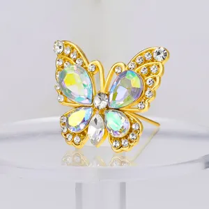 Primer plano detalle broche mariposa de cristal, pedrería brillante en una base de oro.