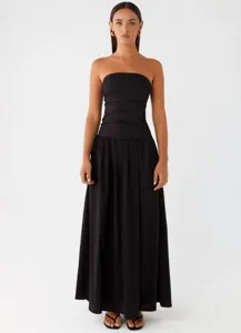 Detail view of the elegant black strapless ruched maxi dress, highlighting craftsmanship.