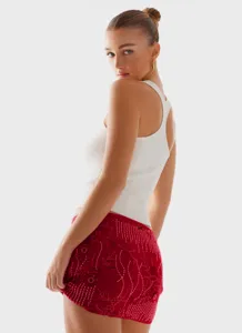 Detailaufnahme von rotem Pailletten-Minirock und weißem Ripp-Top für Damen, stylisch.