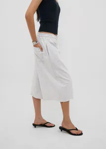 Side view of grey wide-leg cropped sweatpants with raw hems and elastic drawstring waist