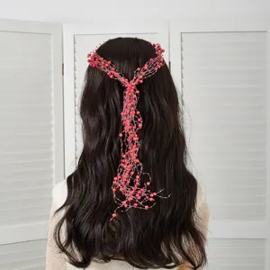 Vue détaillée de la vigne à cheveux en perles rouges pour coiffure de mariée élégante.