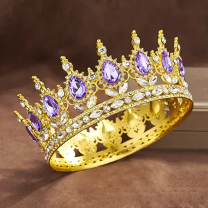 Close-up detail of luxury gold baroque crown featuring purple crystals and clear rhinestones.