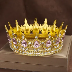 Detailed close-up of a baroque gold round crown featuring pink teardrop rhinestones and clear crystals.