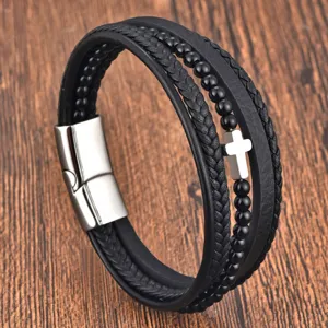 Close-up detail of multi-layer black leather and bead bracelet with stainless steel cross.