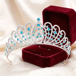 Close-up detail of silver rhinestone crown with sparkling blue crystals in velvet gift box