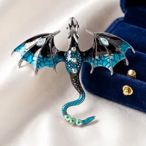 Detailopname van een retro vliegende draak broche met blauw email en glinsterende strass.