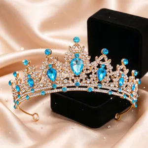 Dettaglio squisito di tiara nuziale in cristallo, strass blu scintillanti e corona dorata per matrimoni.