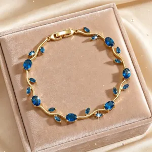 Detailed close-up of a chic gold-plated vine bracelet adorned with sparkling blue cubic zirconia.