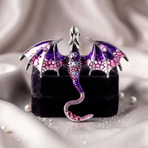 Gedetailleerde close-up van de retro paarse en roze geëmailleerde drakenbroche met strass.
