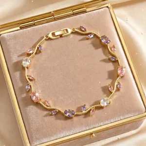 Chic gold-tone vine crystal bracelet with sparkling pink and purple zircon stones in a velvet box.
