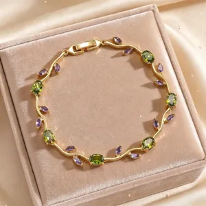 Exquisite gold-toned branch design bracelet featuring vibrant green and purple cubic zirconia stones.