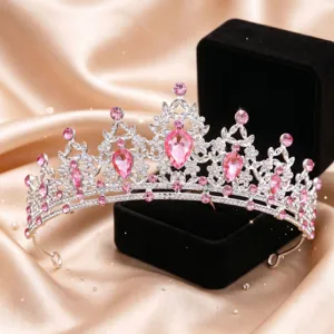Primo piano dettagliato di una tiara argentata con cristalli rosa e strass scintillanti.