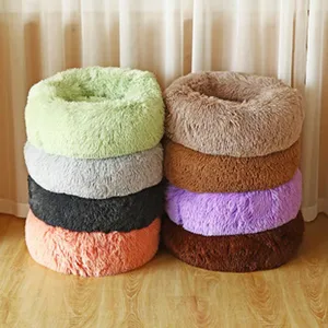 Selection of colorful round plush pet beds stacked in a cozy indoor setting