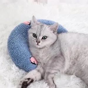 Detailaufnahme eines weichen blauen Halbmond-Plüschkissen und Tierspielzeugs für Katzen, gemütlich.