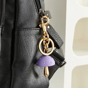 Schattige paarse paddenstoel tasbedel met strass-steentjes en goudkleurige hardware details.
