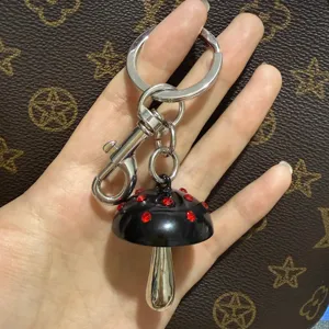 Schattige zwarte paddenstoel sleutelhanger met rode strass steentjes en metalen tas bedel voor dames.