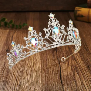 Crystal rhinestone tiara close-up, bridal hair accessory detail on wooden background.