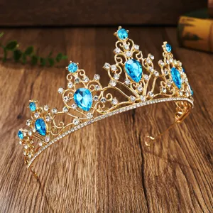 Exquisite detail view of the golden bridal tiara showcasing sparkling blue rhinestones and gems.