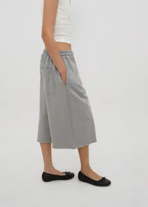 Side view of grey wide-leg sweatpants with elastic waist and raw hem detail