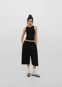 Full view of minimalist women's black retro drawstring wide-leg pants on studio model