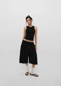 Streetwear look with black wide-leg drawstring shorts and ribbed tank top