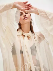 Elegant white sheer ruffled blouse with bow tie neck and voluminous lantern sleeves
