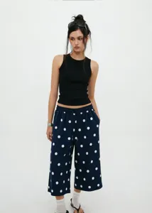 Full styling view of navy blue polka dot wide-leg pants with black ribbed tank top