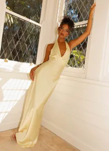 Elegant detail view of a champagne satin halter maxi dress featuring a sexy deep V-neckline.