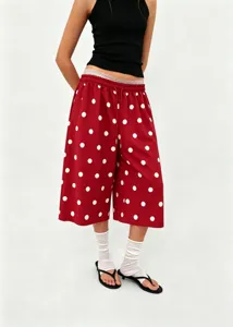 Detail showing women's red polka dot wide-leg pants paired with white socks and sandals