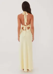 Back view of a pale yellow satin halter dress featuring an open back with tie details.