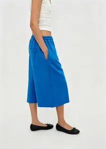 Detailed side view of bright blue wide-leg cropped pants with comfortable elastic waist